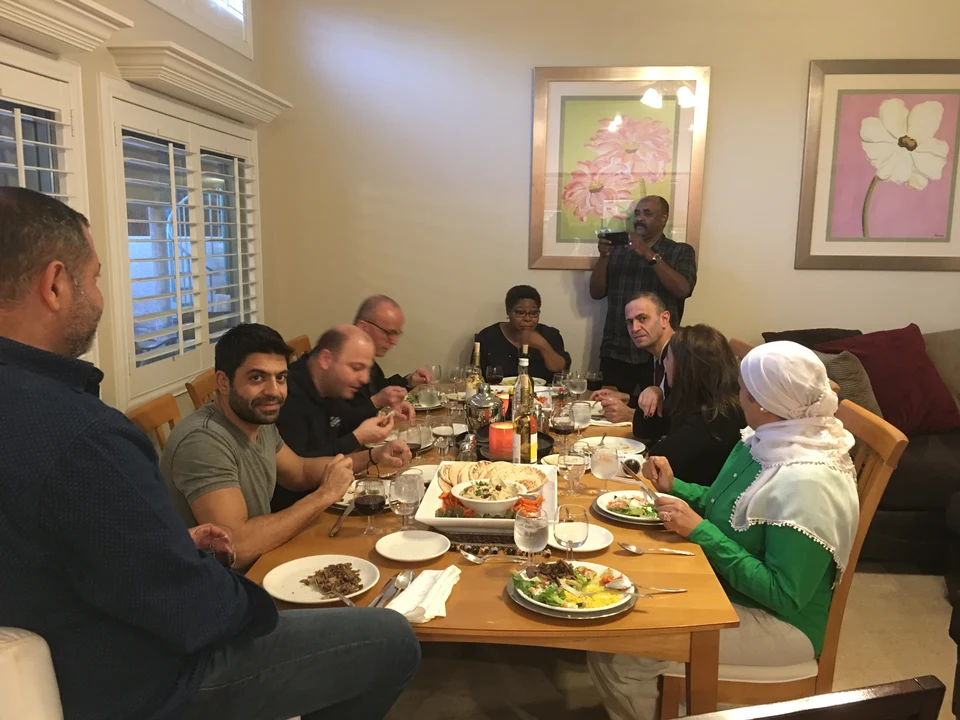 International visitors and local hosts gathered around a dining table in the WACLV Home Hospitality archive